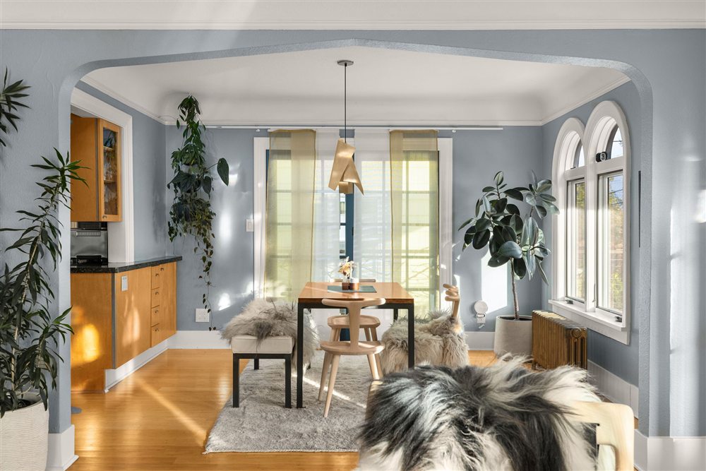 Light-filled dining room opening to the kitchen with arched windows