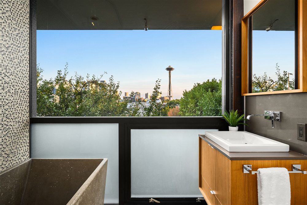Primary bath with a soaking tub framing a view of the Space Needle
