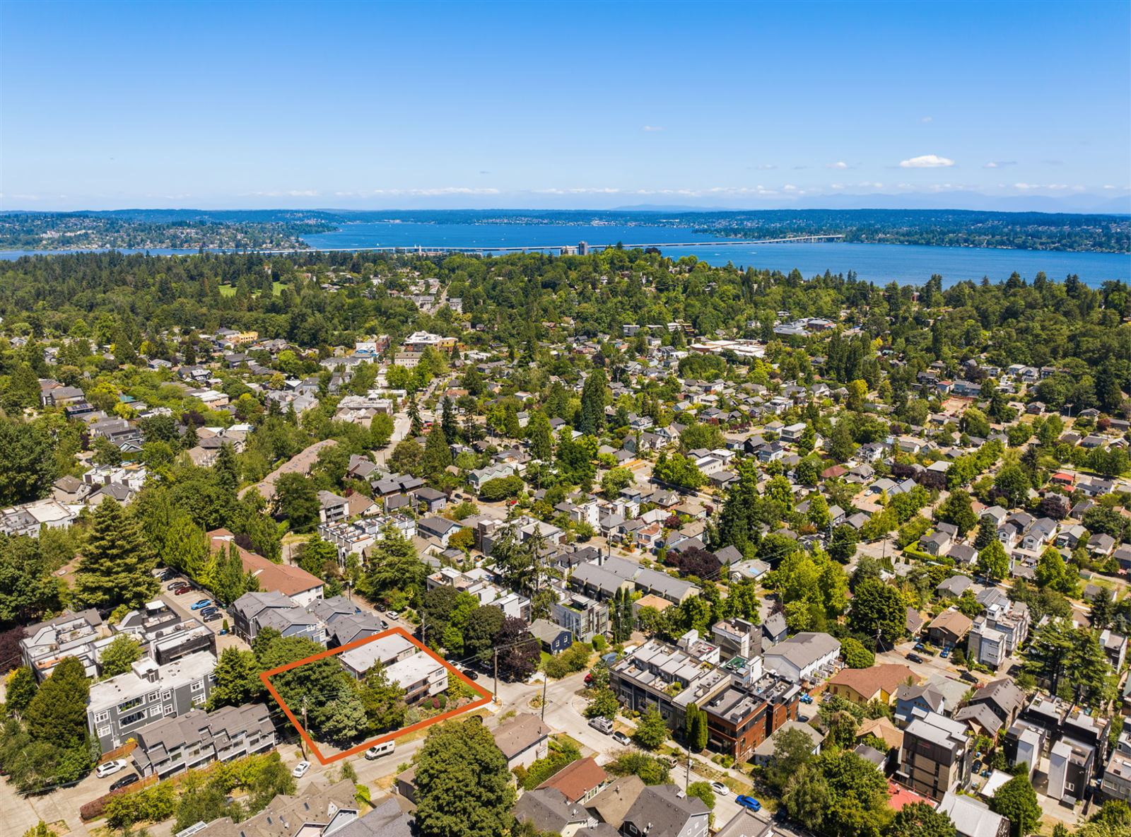 Aerial view of the property with its approximate lot line outlined in orange, Lake Washington and the 520 bridge beyond
